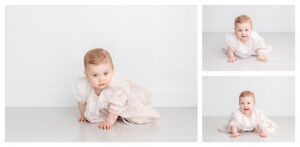 baby photographed in a white studio backgorund wearing her christening gown