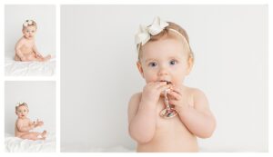 baby photographed in studio with a bow in her hair and she is holding a silver rattle