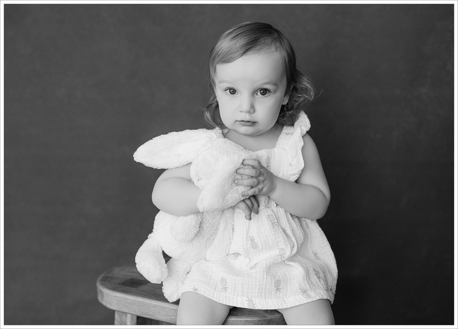 toddler girl photographed on a black backdrop in studio in st simons island for the childhood edit portrait series